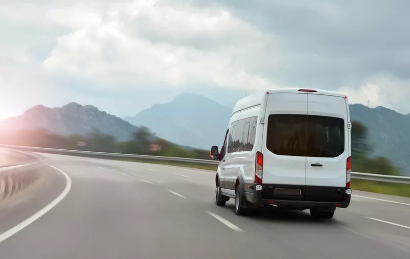 Bild von einem Kleinbus auf einer Straße, umgeben von Bäumen